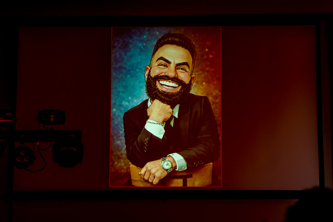 Matthew Laken caricature featured on screen at an event